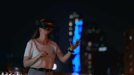 Young-woman-in-virtual-reality-glasses-against-the-background-of-the-night-city-using-graphics-application-interface.-Play-virtual-reality-games.-Modern-technology-in-urban-life